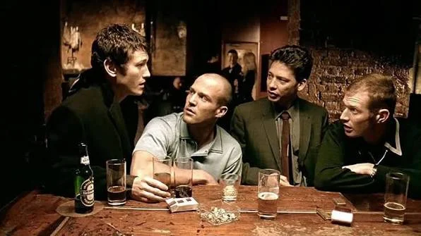 Cena do filme “Jogos, Trapaças e Dois Canos” (1998) — estreia de Guy Ritchie, onde uma partida de pôquer desencadeia uma avalanche de eventos criminosos.